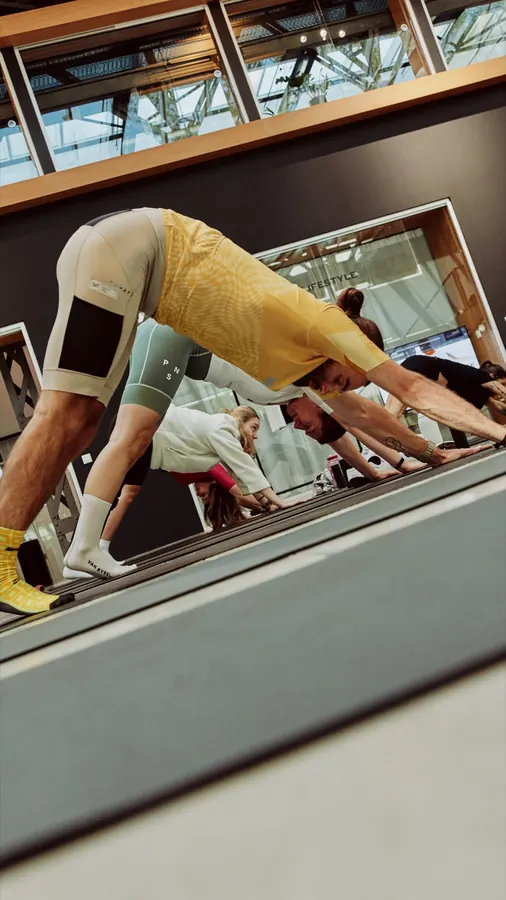 Eine Person im Downward Dog in einer Halle mit Holzdecke