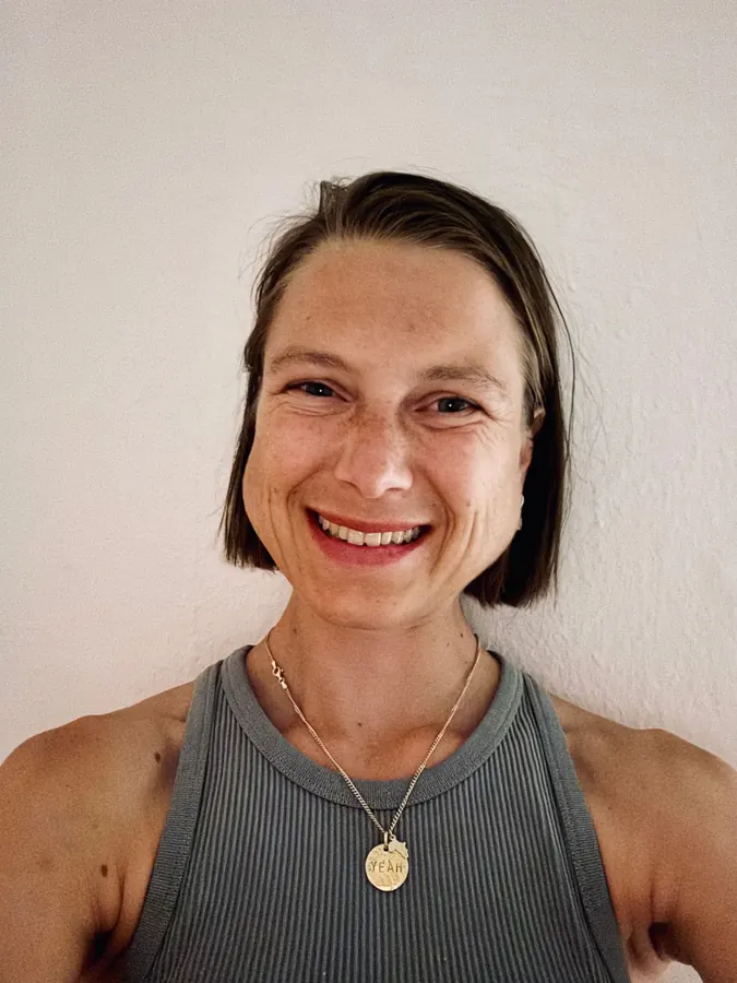 Porträt von Sophie Friedrich, lachend, vor heller Wand